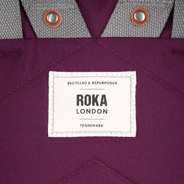 Roka London recycled cherry lacquer canvas tote bag with gray fabric accents and metal button details.