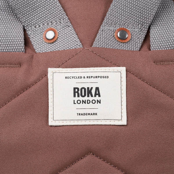 Roka Finchley A Coco recycled canvas tote bag with gray straps and metal snaps, featuring a white label and brown fabric exterior.