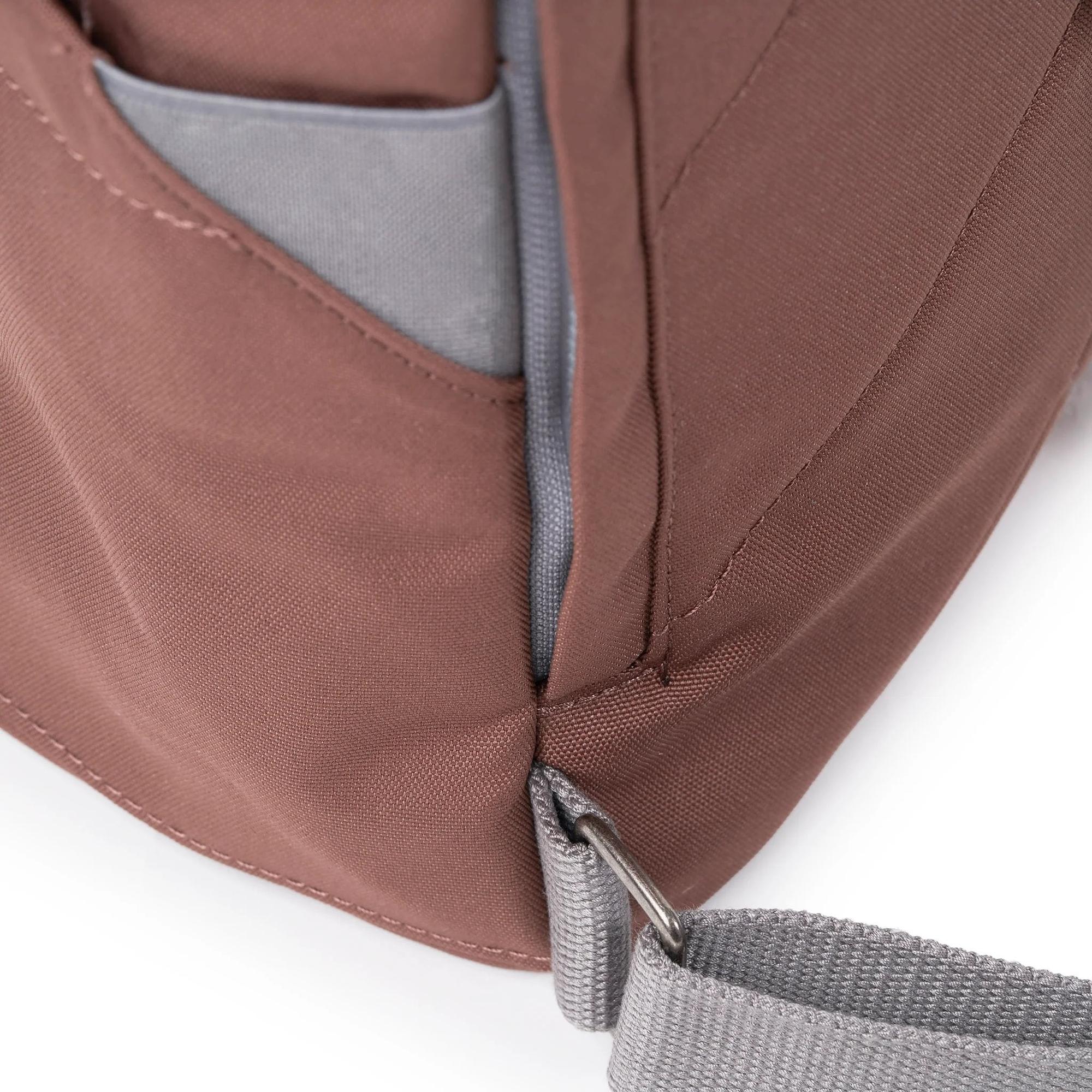 Roka Finchley A Coco recycled canvas backpack with gray zipper, pocket, and adjustable strap, in brown color.