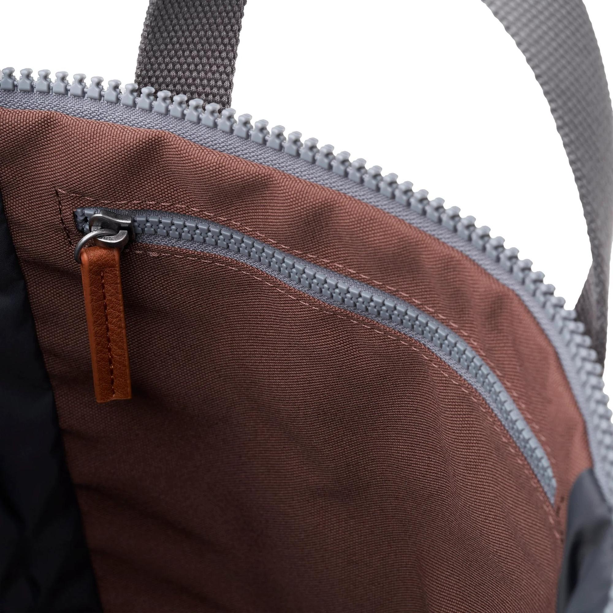 Close-up of Roka Finchley A Coco recycled canvas tote bag interior with zippered pocket, brown lining, and leather zipper pull.