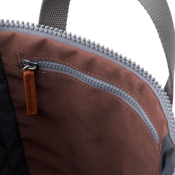 Close-up of Roka Finchley A Coco recycled canvas tote bag interior with zippered pocket, brown lining, and leather zipper pull.