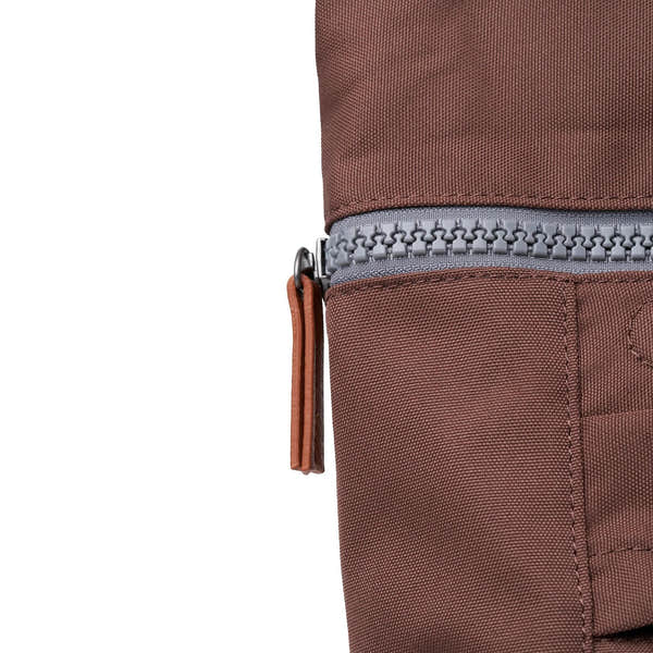 Roka Finchley A Coco recycled canvas bag with a grey zipper and tan leather pull tab, close-up detail of durable textured fabric.