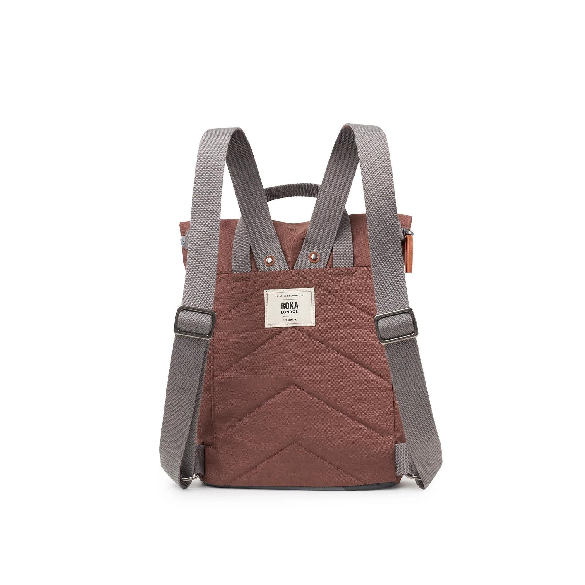 Roka Finchley A Coco recycled canvas backpack with grey adjustable shoulder straps, front pocket, and white logo patch.