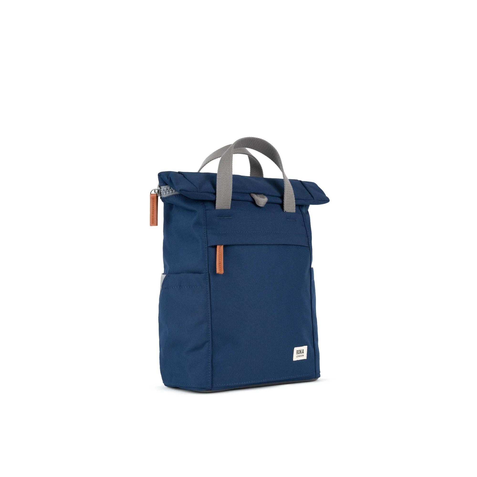Roka Finchley backpack in blue recycled canvas with gray handles and orange zipper pulls, stylish eco-friendly everyday bag.