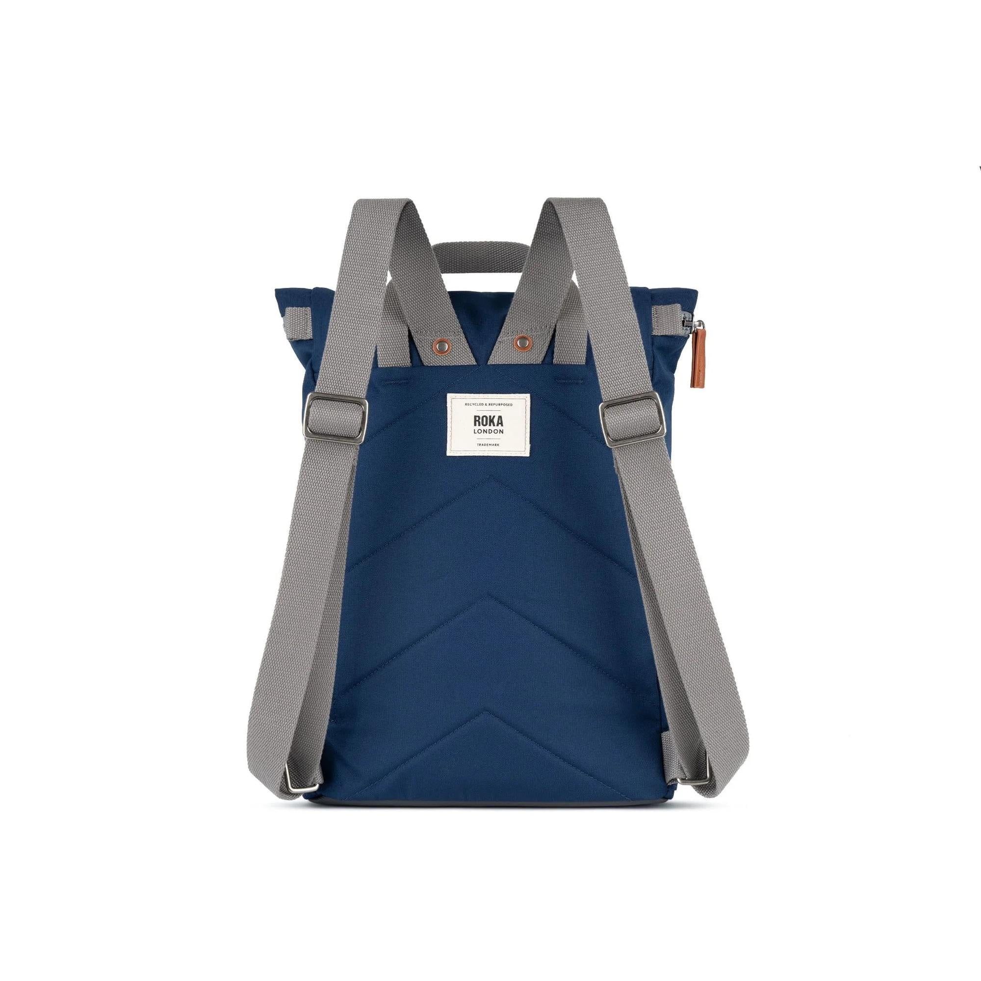 Roka Finchley backpack in crisp blue recycled canvas with grey adjustable straps and a white label, eco-friendly and stylish.