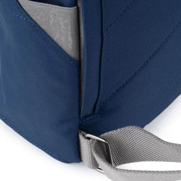 Roka Finchley backpack in crisp blue recycled canvas with gray strap and side pocket, close-up shot highlighting material and design.