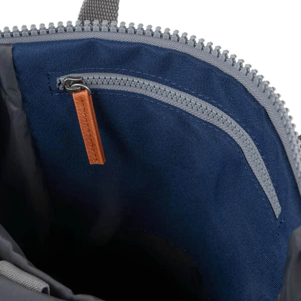 Roka Finchley blue recycled canvas backpack interior with zippered pocket and tan leather zipper pull.