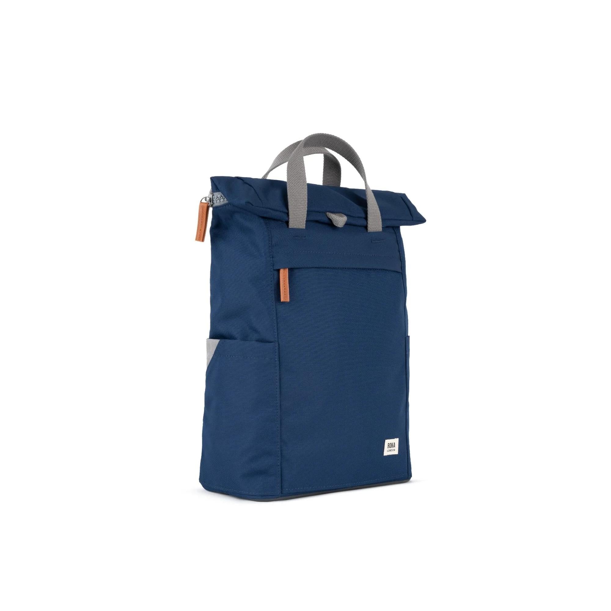 Roka Finchley blue recycled canvas backpack with grey handle and orange zipper accents.