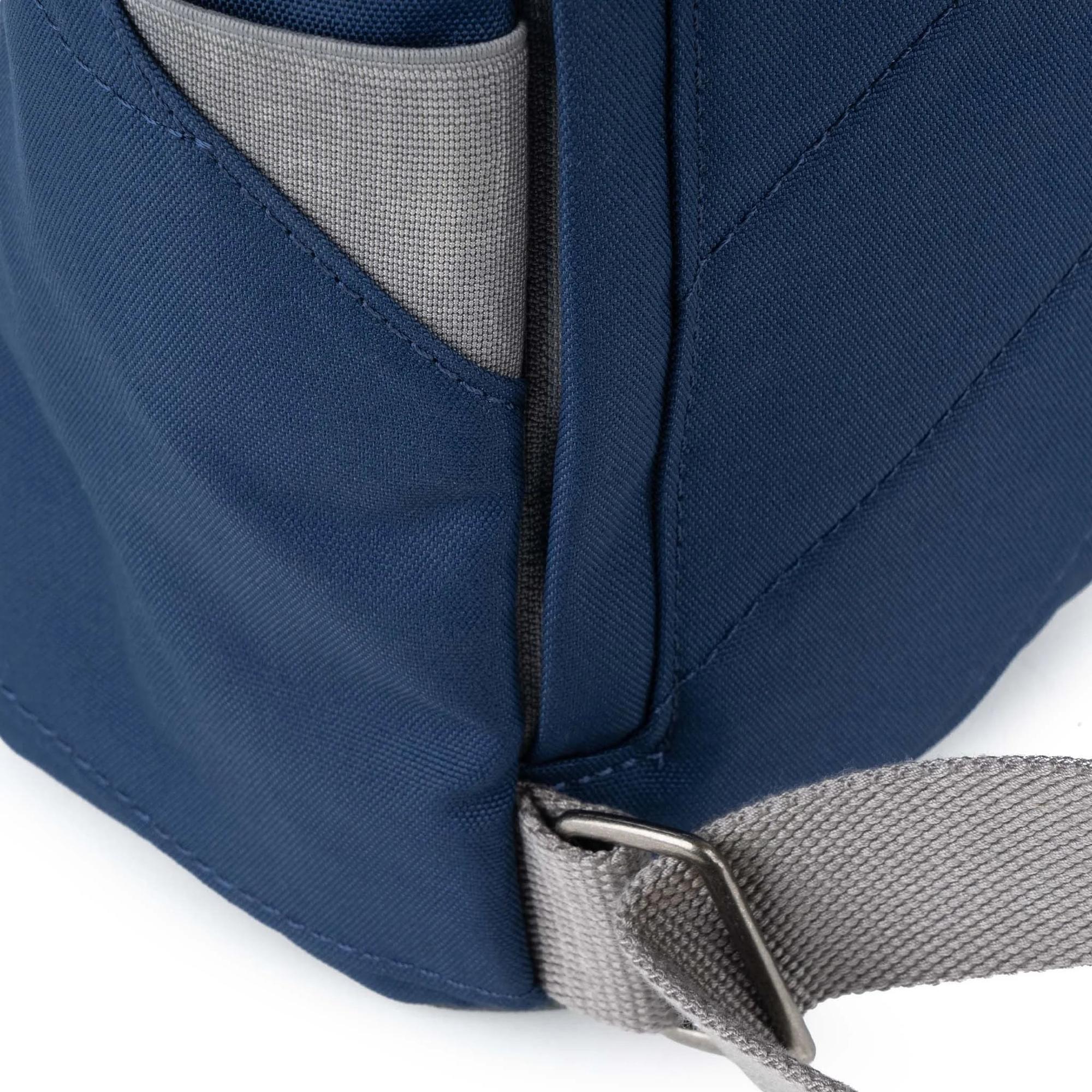 Roka Finchley blue recycled canvas backpack with grey strap and side pocket, durable and eco-friendly design.