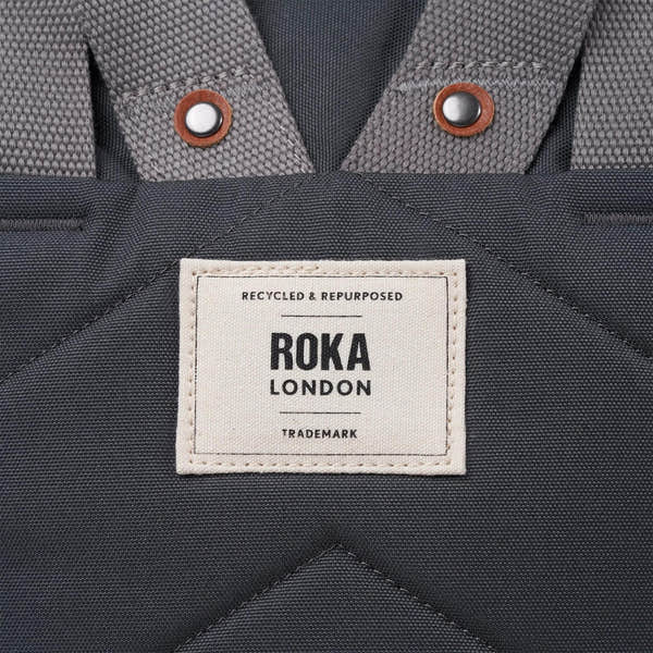 Roka Finchley A Faded Black Recycled Canvas backpack with padded straps and a front label.