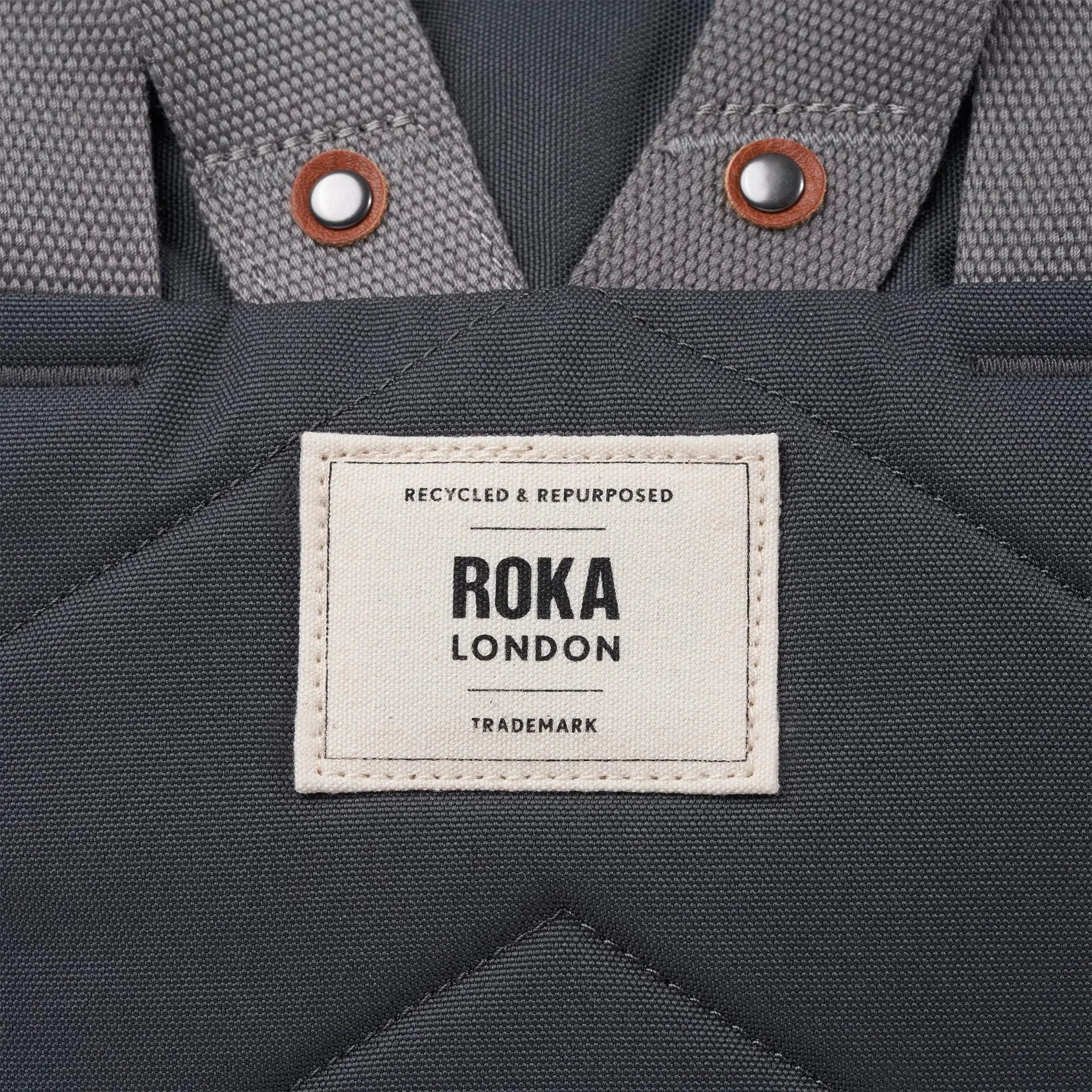Roka Finchley A Faded Black Recycled Canvas backpack with padded straps and a front label.