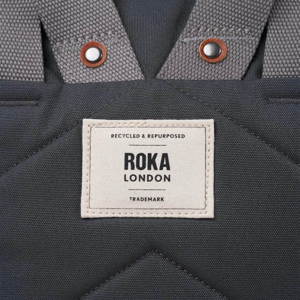 Roka Finchley A Faded Black Recycled Canvas backpack with padded straps and a front label.