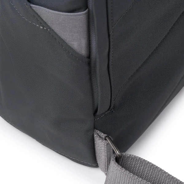 Roka Finchley A Faded Black Recycled Canvas backpack with gray strap and front pocket detail.