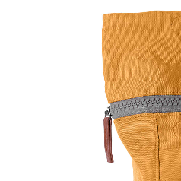 Roka Finchley A Flax recycled canvas bag with a grey zipper and leather pull tab, in mustard yellow color.