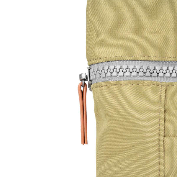 Roka Finchley A Khaki Recycled Canvas backpack with silver zipper and leather pull tab, close-up detail.