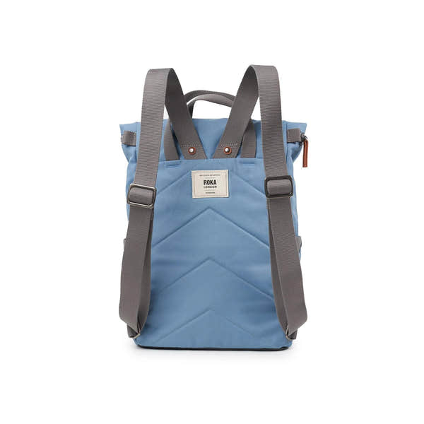Roka Finchley backpack in retro blue recycled canvas with grey adjustable straps and front label, stylish eco-friendly design.