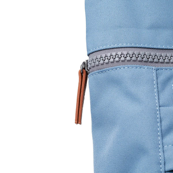 Roka Finchley A Retro Blue Recycled Canvas backpack with grey zipper and tan leather pull tab.