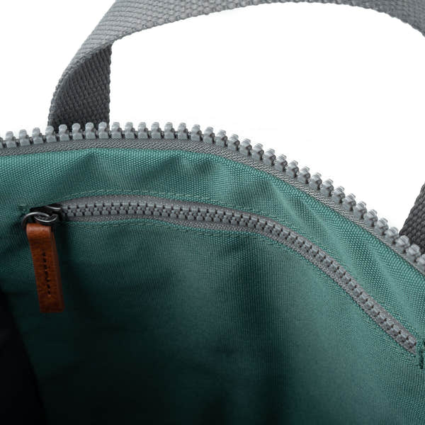 Close-up of Roka Finchley A Sage Recycled Canvas bag interior with zipper and leather pull tab.