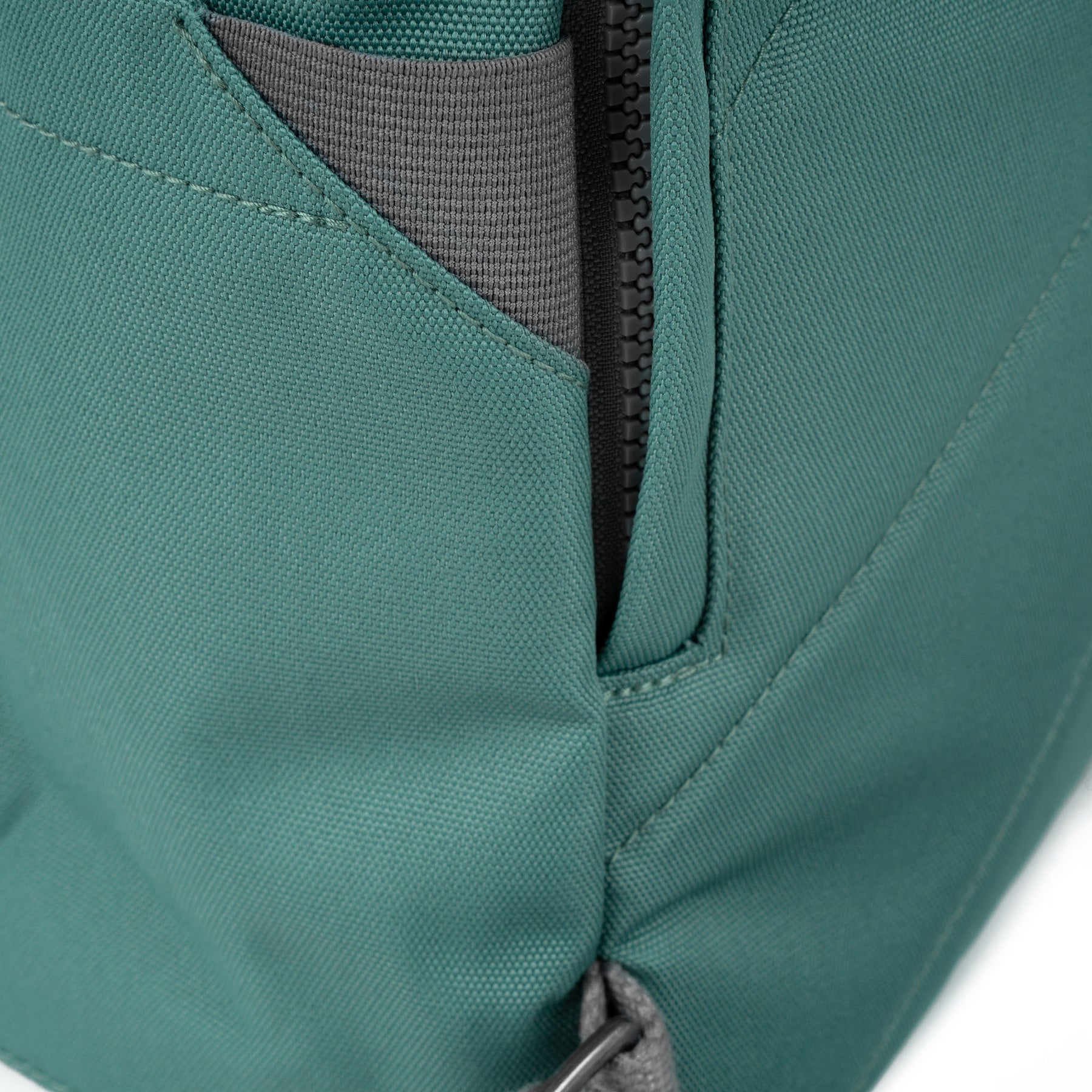 Roka Finchley A Sage recycled canvas backpack with zipper pocket detail and grey interior lining.