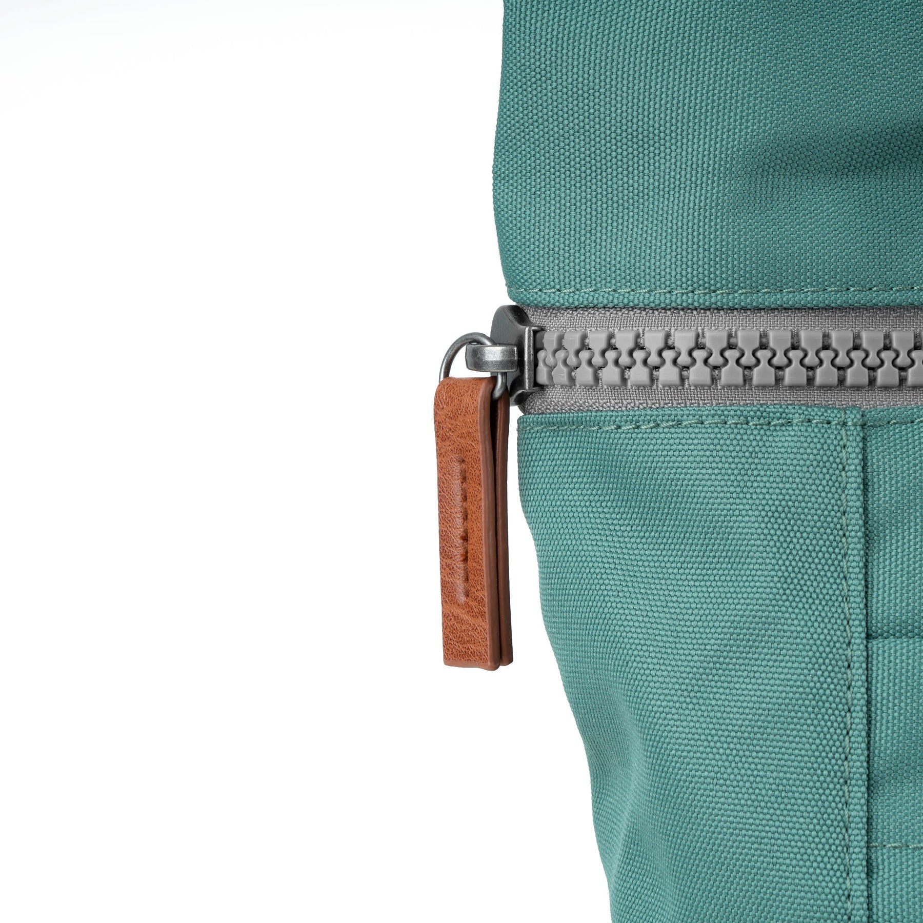 Roka Finchley A Sage Recycled Canvas backpack close-up with zipper and leather pull tab.