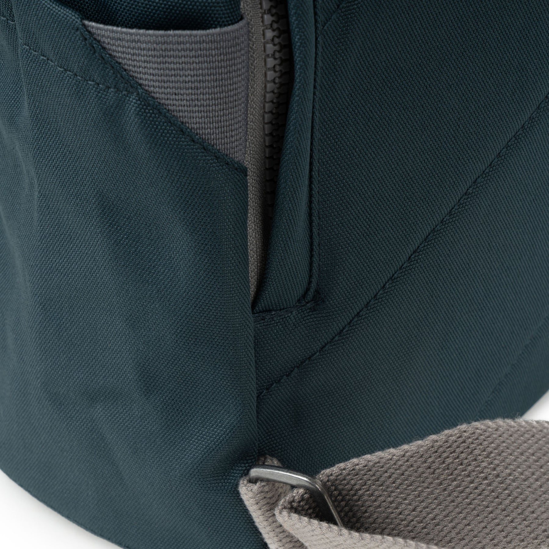 Close-up of Roka Finchley A Smoke recycled canvas backpack, showing textured fabric, zipper, and stitching details.