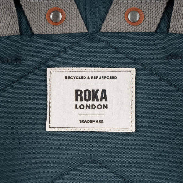 Roka Finchley A Smoke recycled canvas tote bag, close-up of label and textured fabric, grey and teal color, durable style.
