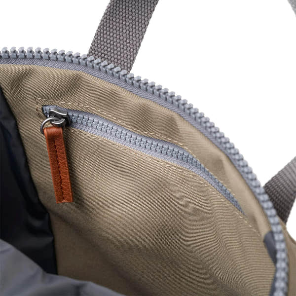 Roka Finchley A Taupe Recycled Canvas backpack interior with zippered pocket and brown leather pull tab.