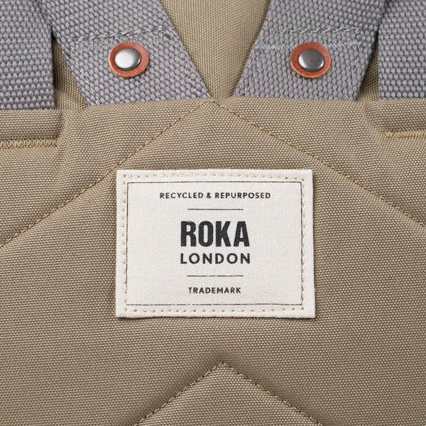 Roka Finchley taupe recycled canvas bag with fabric details and metal button accents.