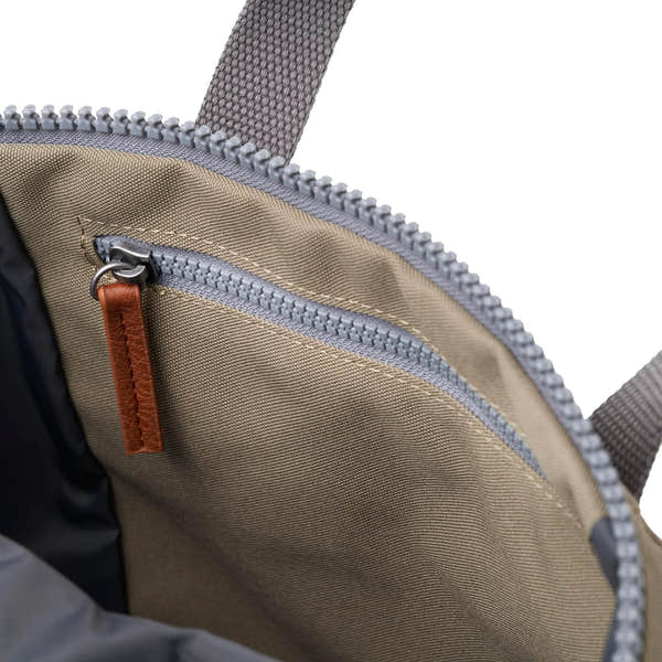 Roka Finchley A Taupe Recycled Canvas backpack interior with zippered pocket and leather pull tab, showcasing stylish and eco-friendly design.