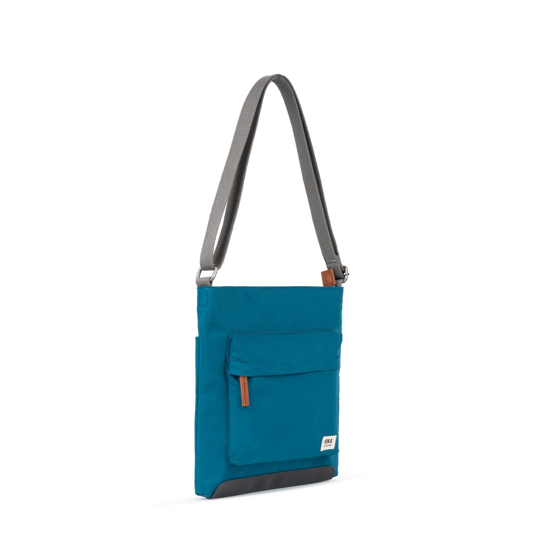 Roka Kennington B Crossbody Bag in recycled nylon with sapphire color, adjustable strap, front pocket, and logo detail.