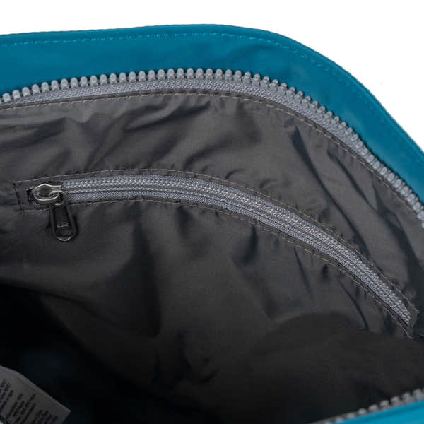 Roka Kennington B Crossbody bag in recycled nylon Sapphire with interior zip pocket and grey lining.