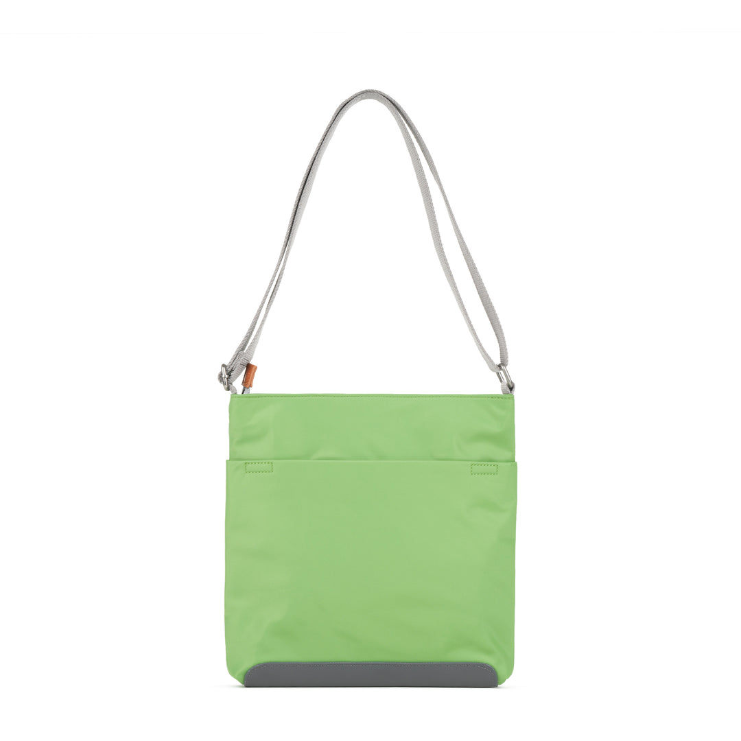 Roka Kennington B Kiwi recycled nylon crossbody bag with gray strap and gray bottom detail. Bright lime green color.