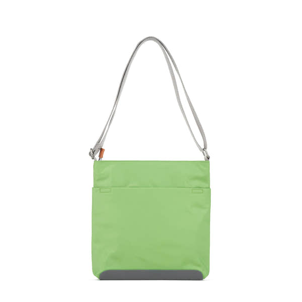 Roka Kennington B Kiwi recycled nylon crossbody bag with gray strap and gray bottom detail. Bright lime green color.