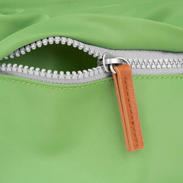 Roka Kennington B Kiwi Recycled Nylon backpack with silver zipper and tan leather pull tab, vibrant green color, eco-friendly material.