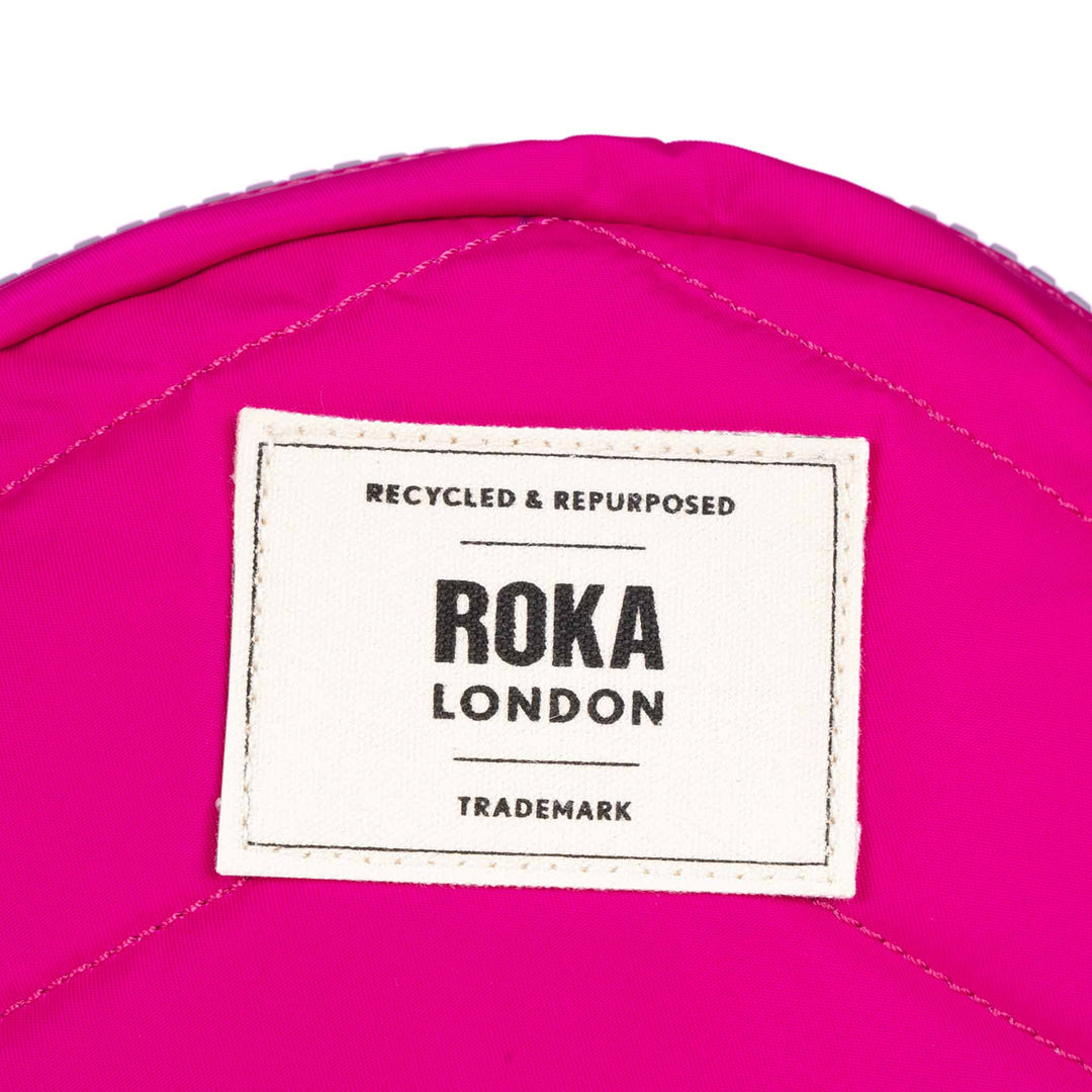 Small pink recycled nylon Roka Paddington B Candy bag with white label, eco-friendly, lightweight, and stylish.