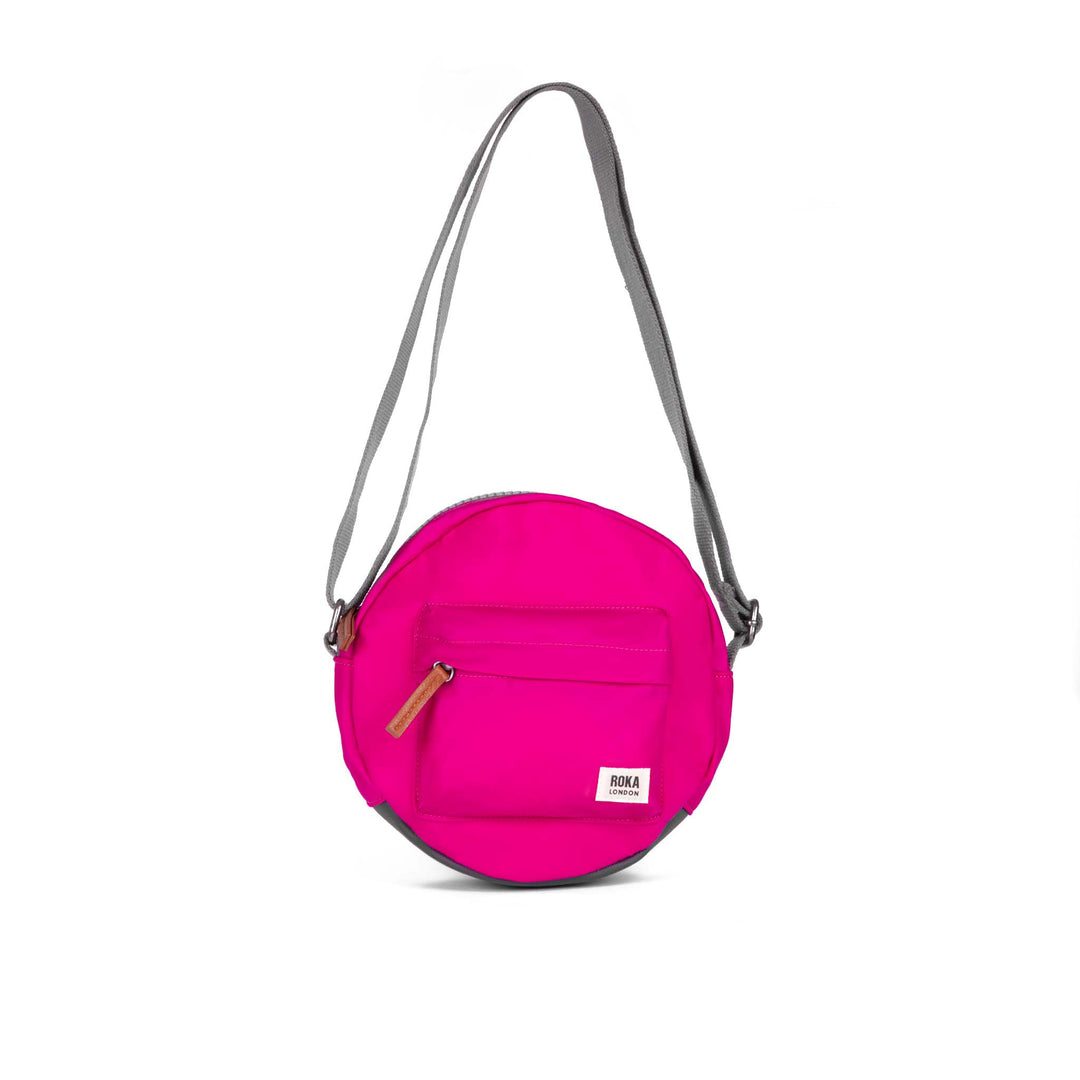 Roka Paddington B Candy small recycled nylon crossbody bag with zip pocket and adjustable strap in pink and gray.
