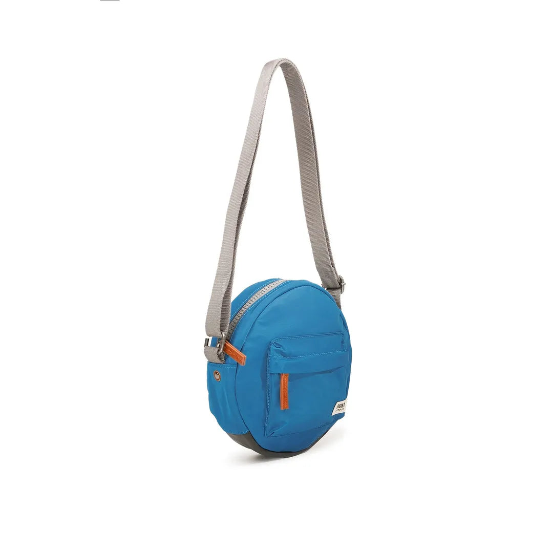 Roka Paddington B Seaport small recycled nylon crossbody bag with front zip pocket and adjustable gray shoulder strap.