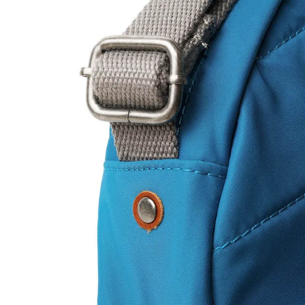 Roka Paddington B Seaport small backpack made from recycled nylon with gray strap and silver buckle.