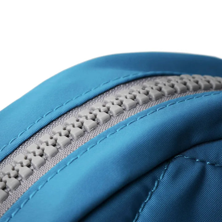 Close-up of Roka Paddington B Seaport small backpack made from recycled nylon fabric with gray zipper and blue stitching.