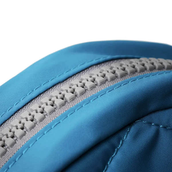 Close-up of Roka Paddington B Seaport small backpack made from recycled nylon fabric with gray zipper and blue stitching.