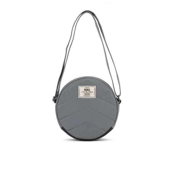 Roka Paddington B Stormy small recycled nylon round shoulder bag with zip closure and adjustable strap.