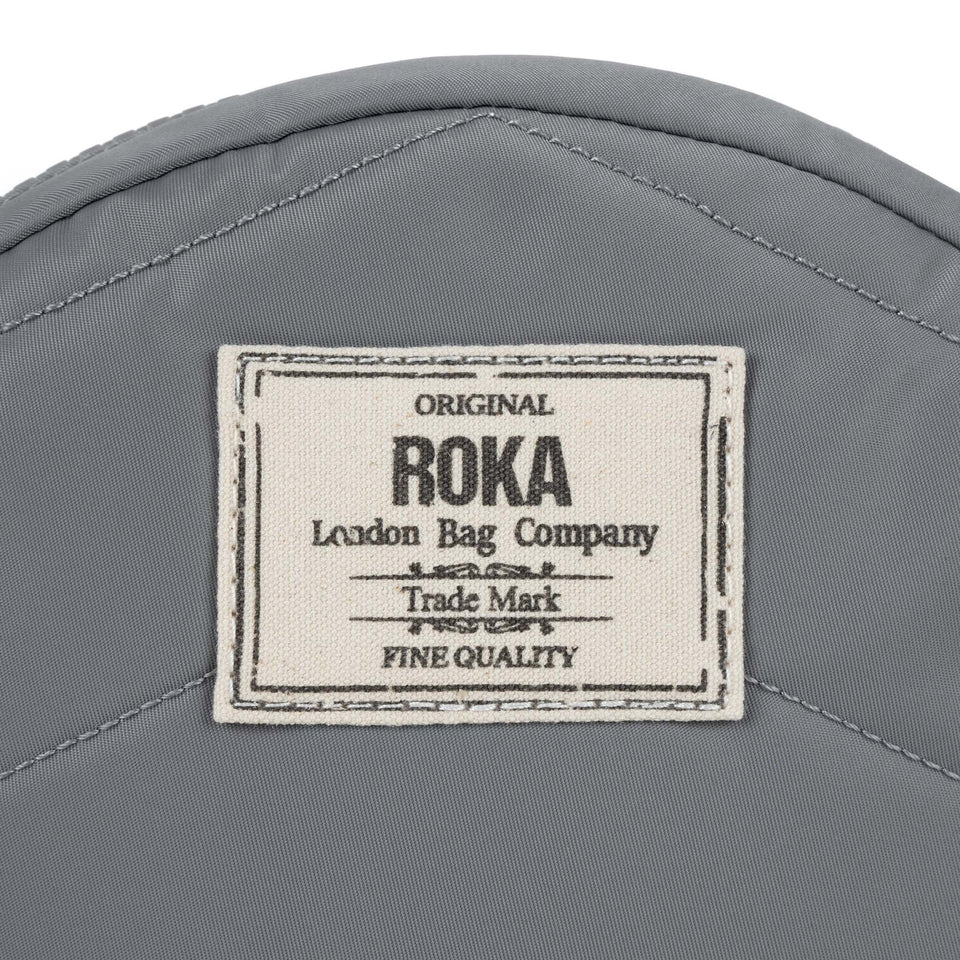 Roka Paddington B Stormy small recycled nylon backpack with logo patch, gray color, compact design, waterproof material.