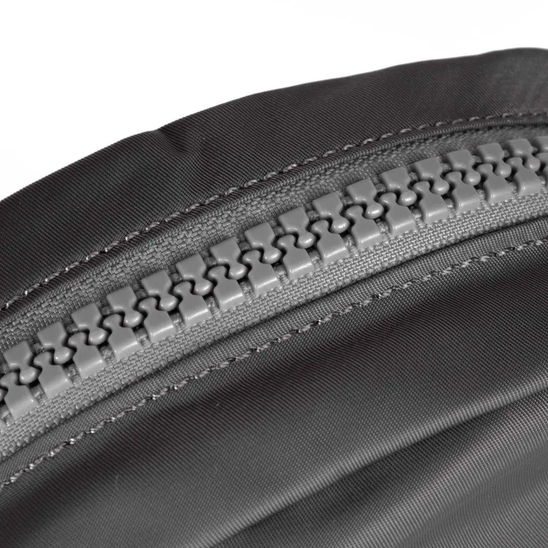 Roka Paddington B Graphite small recycled nylon backpack with a close-up of gray zipper and durable fabric.