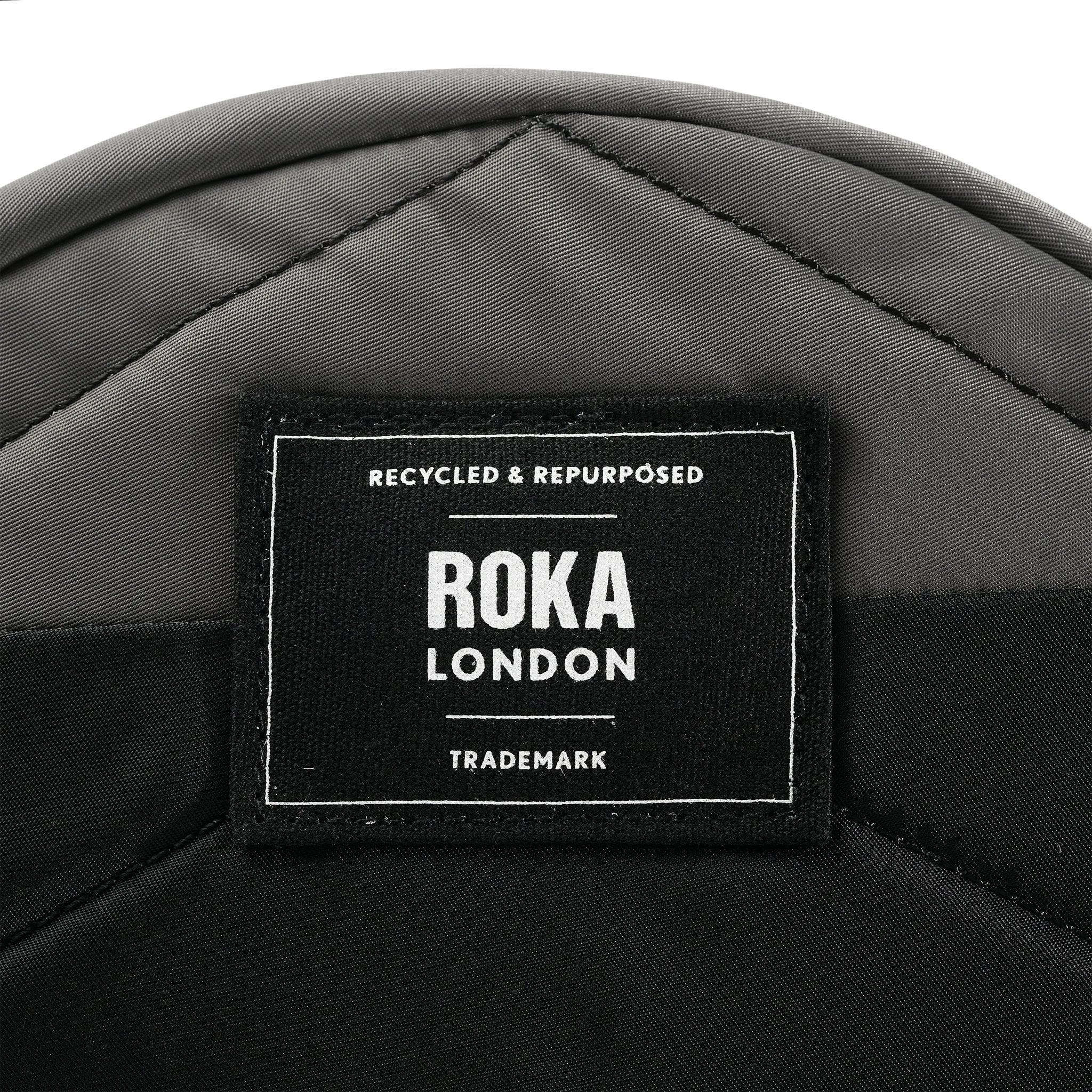 Roka Paddington Graphite Recycled Nylon Crossbody Bag, brand label detail.