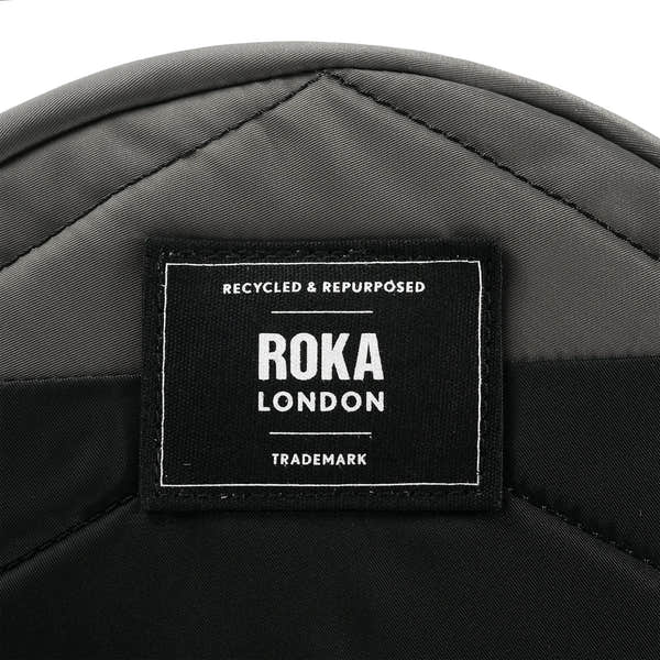Roka Paddington Graphite Recycled Nylon Crossbody Bag, brand label detail.