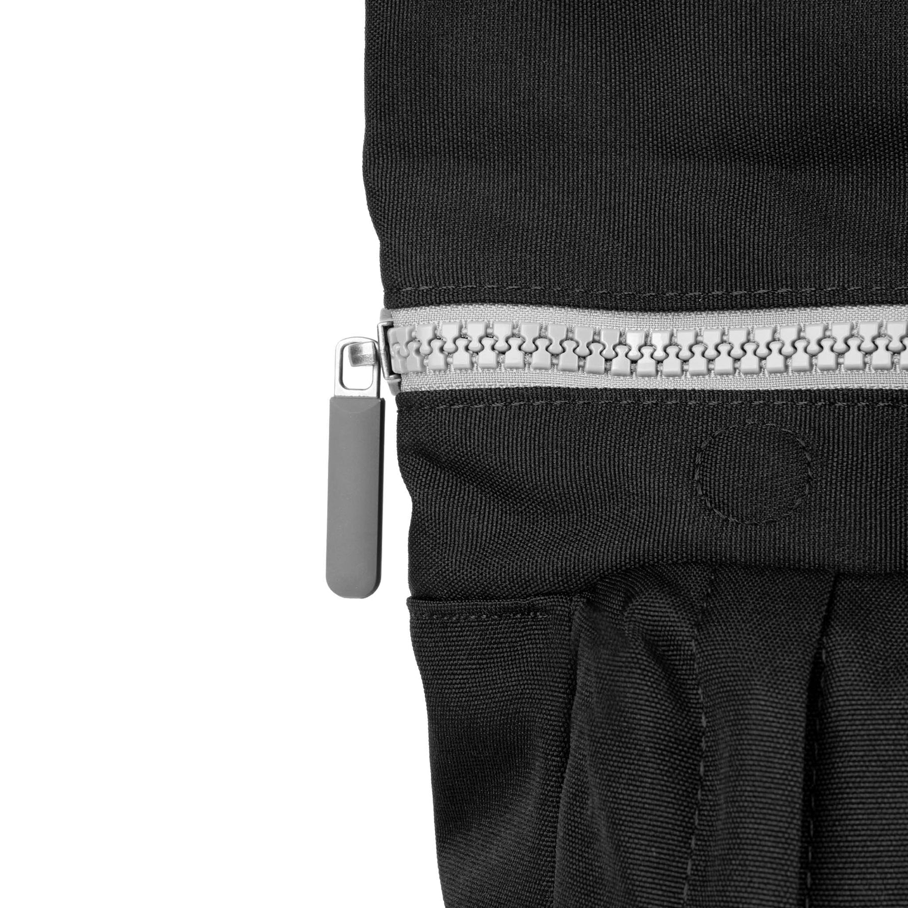 Roka Waterhouse recycled canvas ash-colored bag with silver zipper and black fabric, close-up of zipper detail.