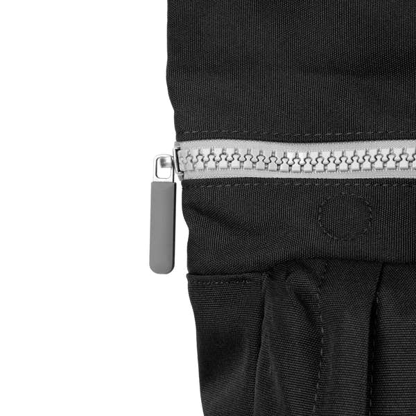 Roka Waterhouse recycled canvas ash-colored bag with silver zipper and black fabric, close-up of zipper detail.