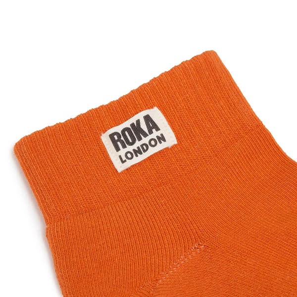 Roka London burnt orange organic cotton one-size headband with logo label, lightweight and stretchy fabric.