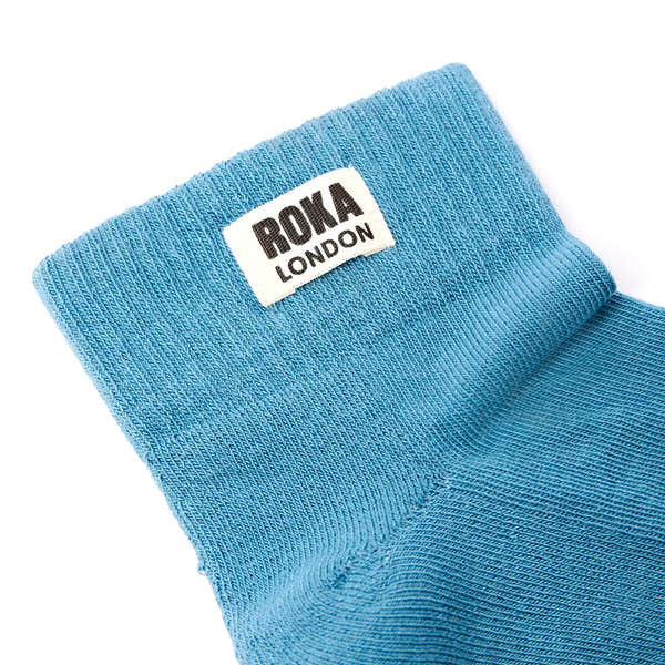 Blue cotton socks with ROKA LONDON logo label, stylish and breathable, Adriatic color, crew length, comfortable fit.
