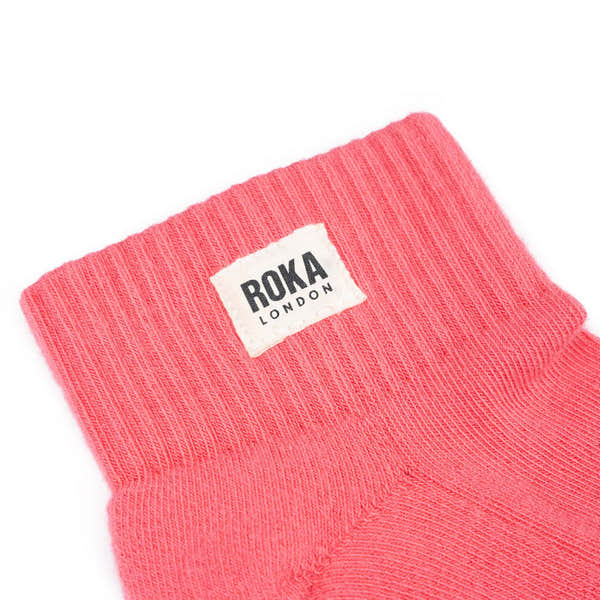 Roka London coral cotton socks with folded cuff and white logo tag, stylish and comfortable footwear accessory.